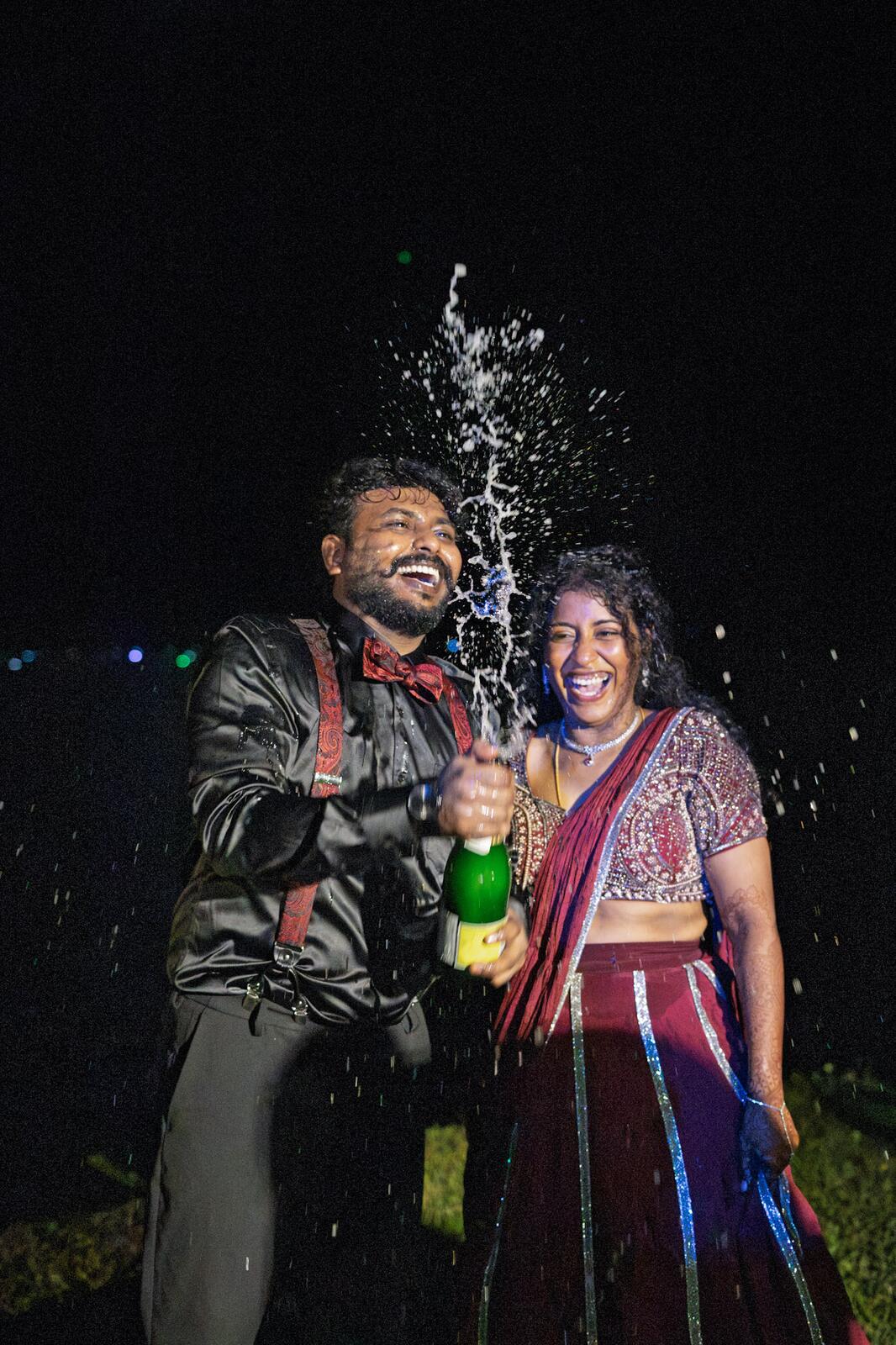 Sakthi popping champagne with Manju at the reception